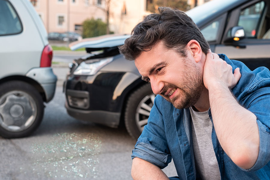 Man holds aching neck after car accident